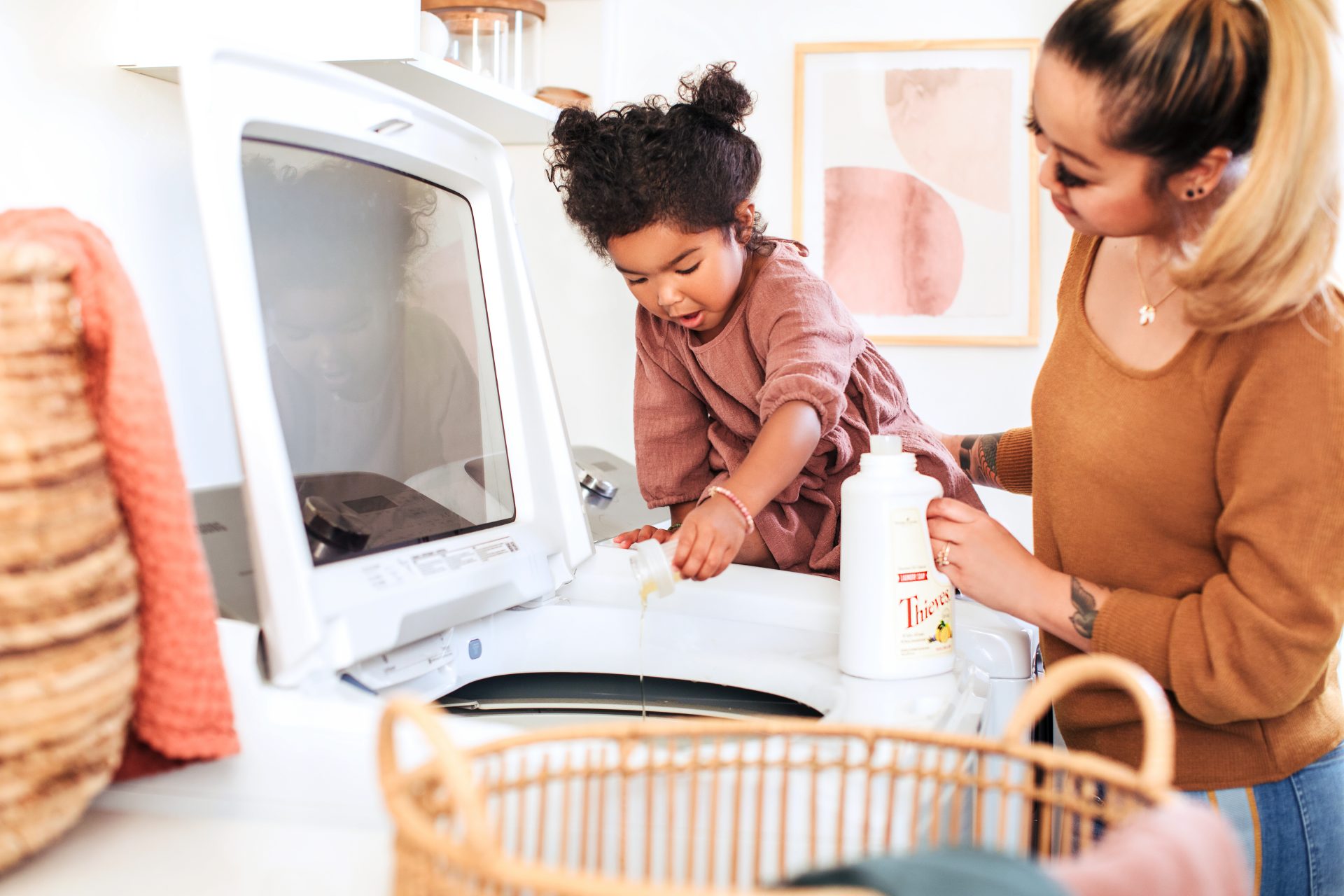 Mom and child doing laundry with Young Living essential oil products